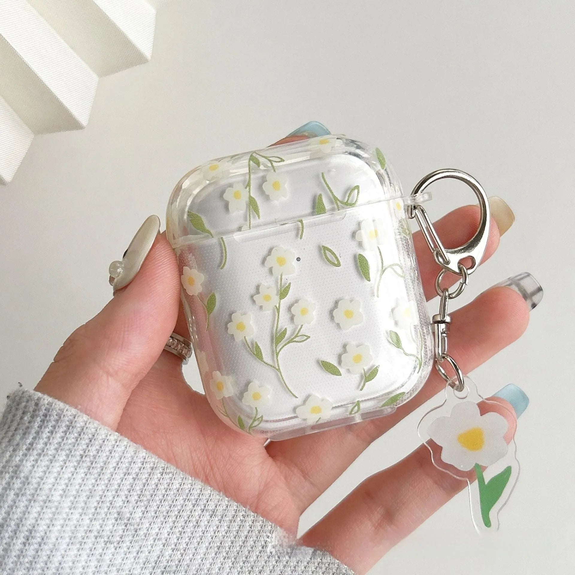 Clear soft TPU protective case for Apple AirPods with white floral oil painting decoration.