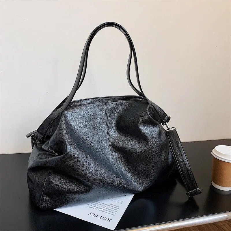 Large black PU leather messenger bag with shoulder strap showing internal organisation pockets