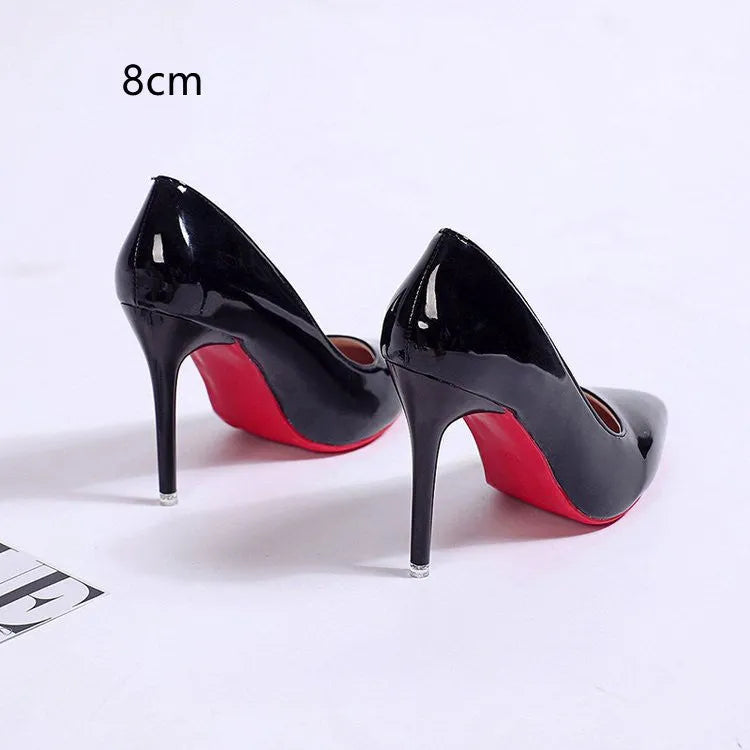 Women's black pointed toe stiletto pumps with a low-cut vamp and thin high heel on a white background.
