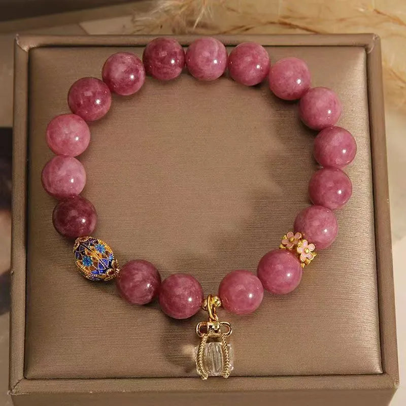Pink and white natural stone bracelet with lotus flower pendant and tassel.