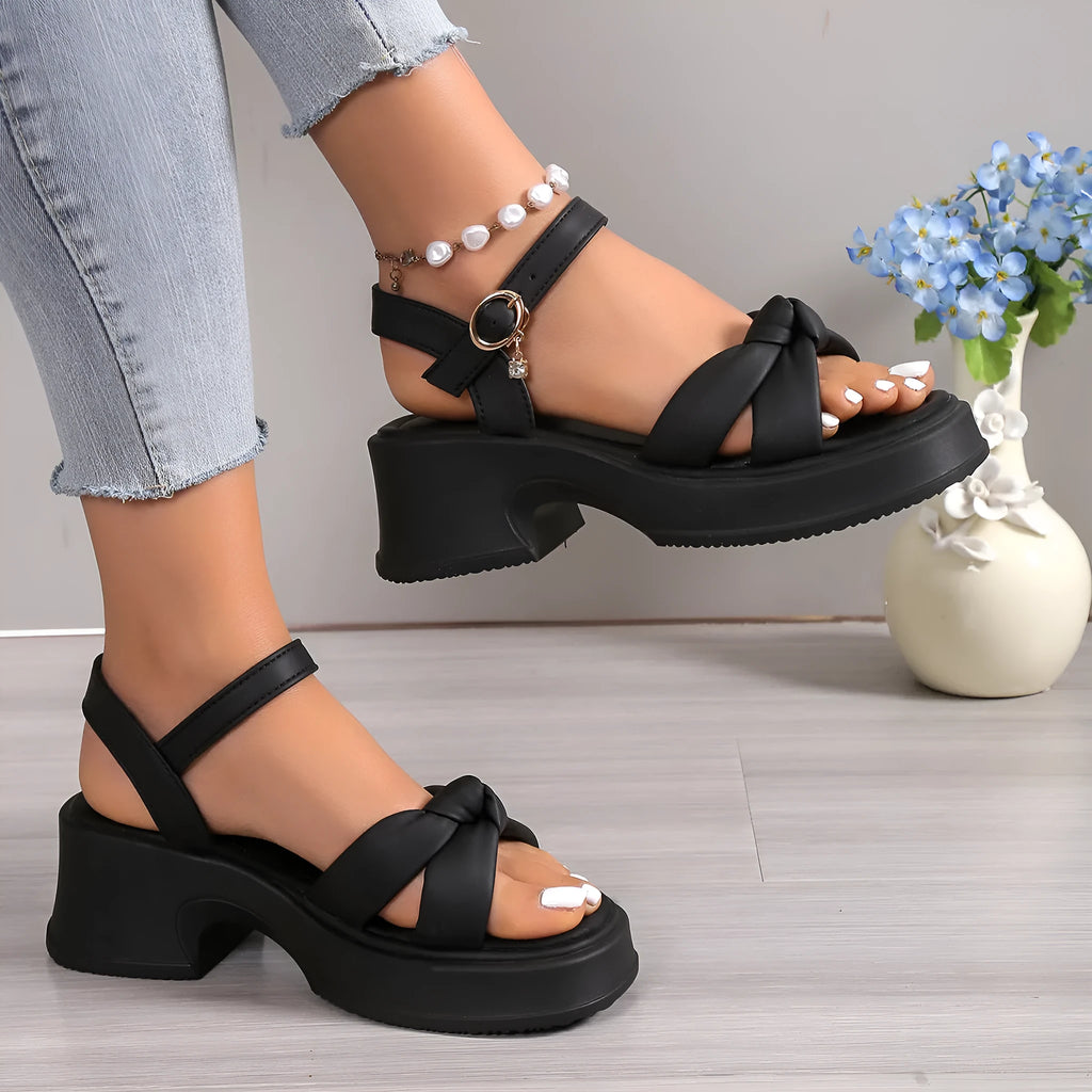 Women's black thick-heel slippers with a button fastening and round toe on a rubber sole.