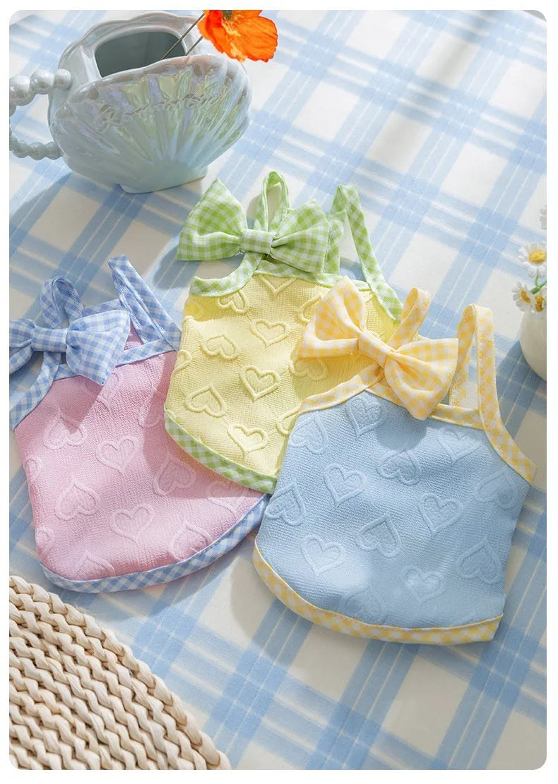 Small dog wearing heart bow suspenders vest in elastic material with decorative bow detail