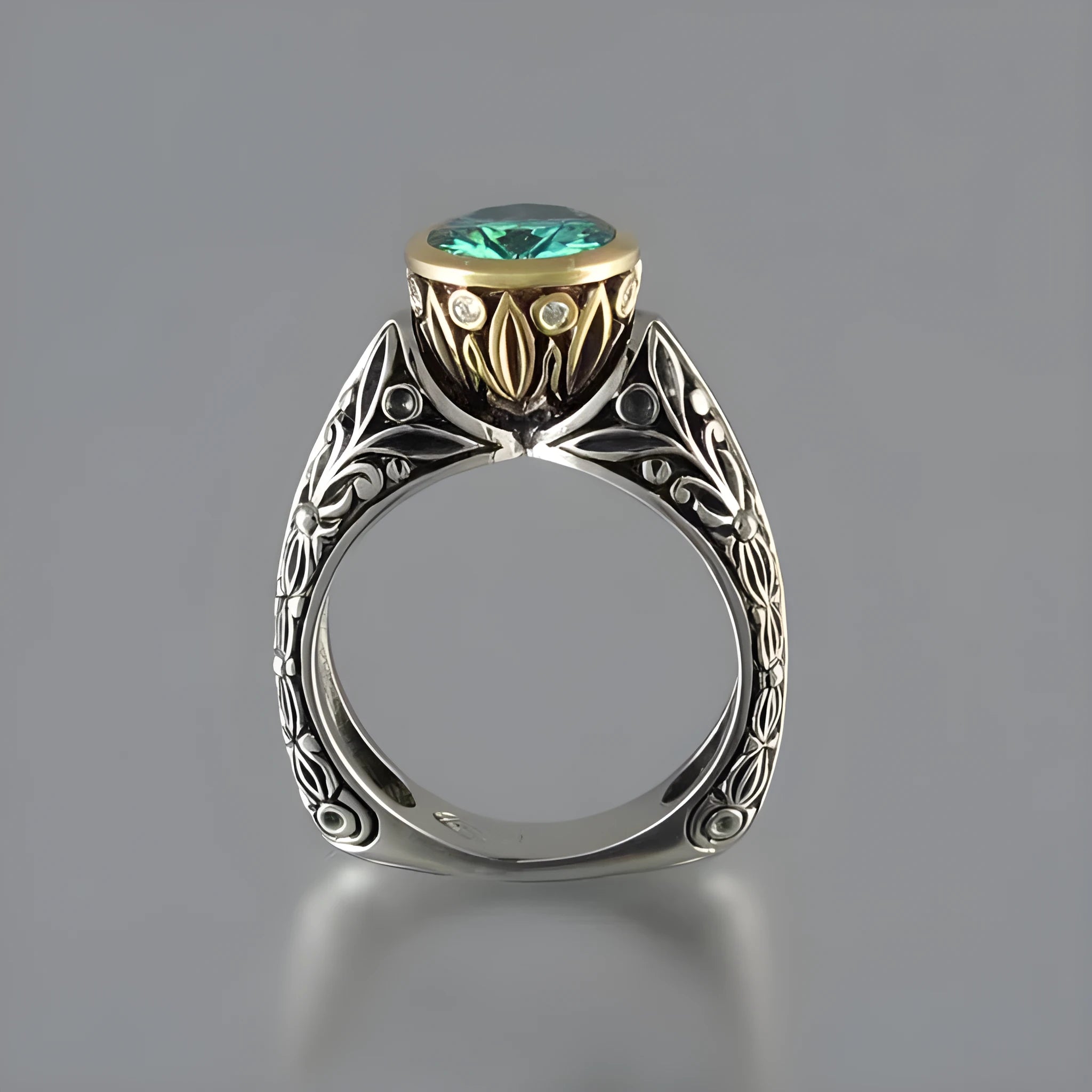 Gold-plated flower-shaped ring with a green gemstone on a silver-tone band, shown from above.