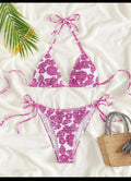 Women's floral print halter neck swimsuit briefs in light blue on a mannequin.