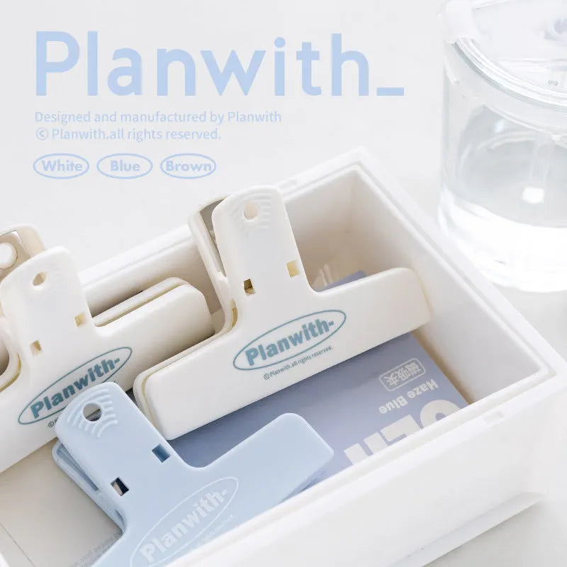 Blue and brown magnetic plastic bill clip holding paper tickets and receipts.