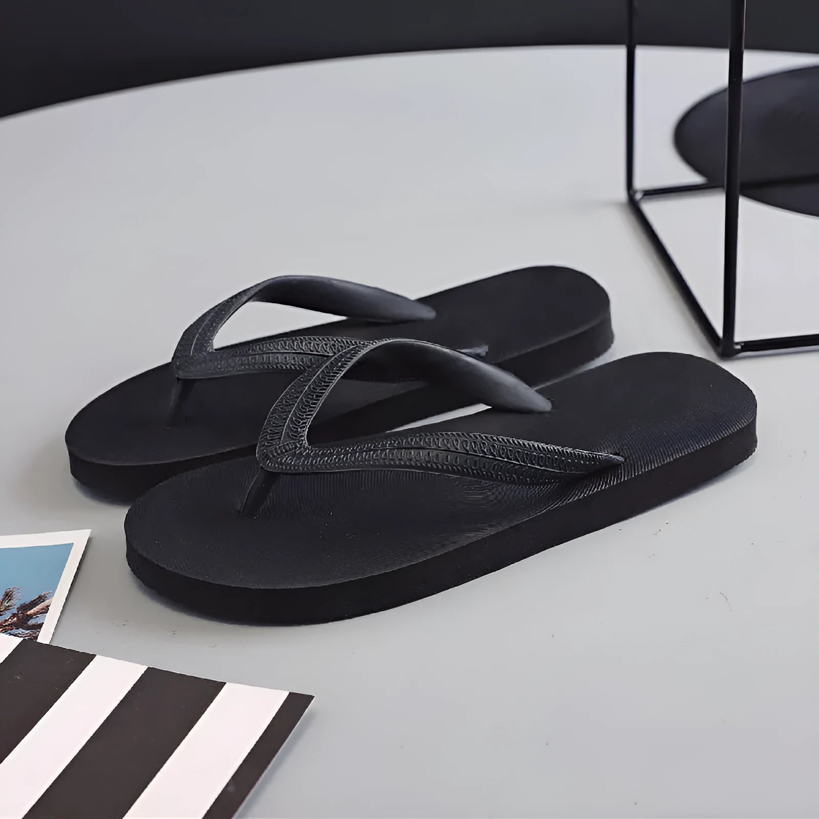 Rubber flip-flops with fish label design in green, red, blue, or black colours on a simple background.