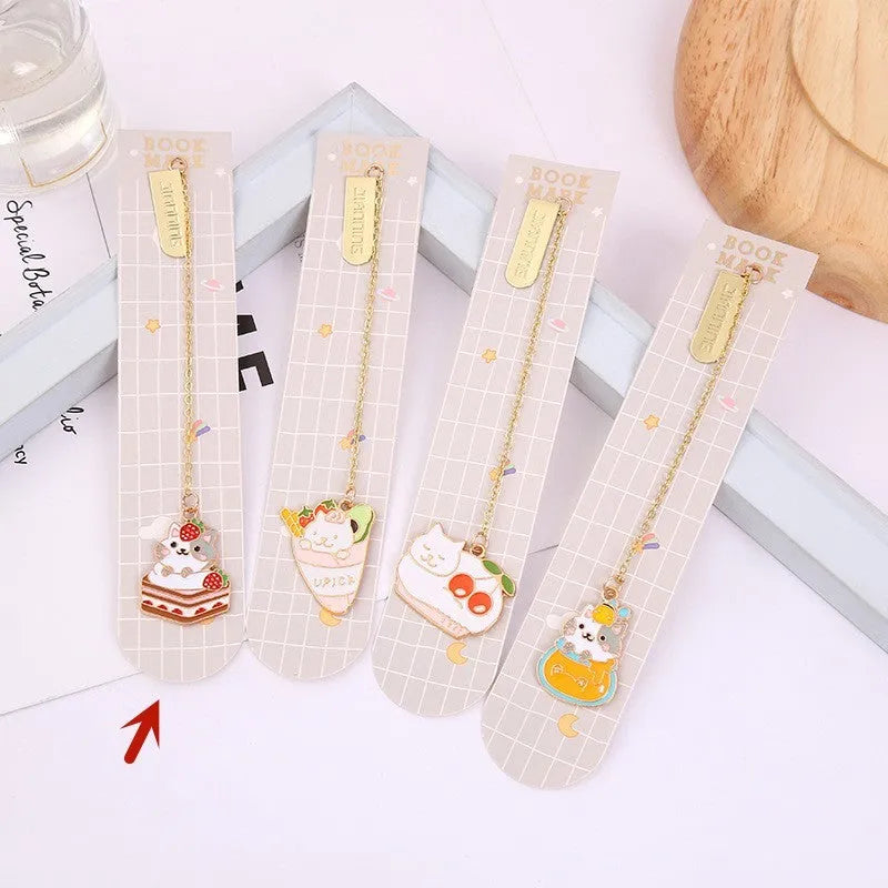 Metal cartoon cat bookmark with food-themed designs including strawberry cake and fruit roll styles