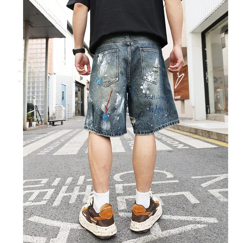 Blue men's ripped denim shorts with graffiti details and straight-leg cut