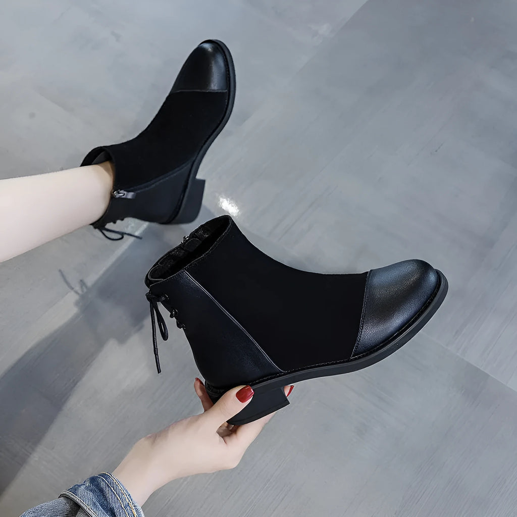 Black women's knee-high martin boots with a side zipper, round toe, and decorative bow.