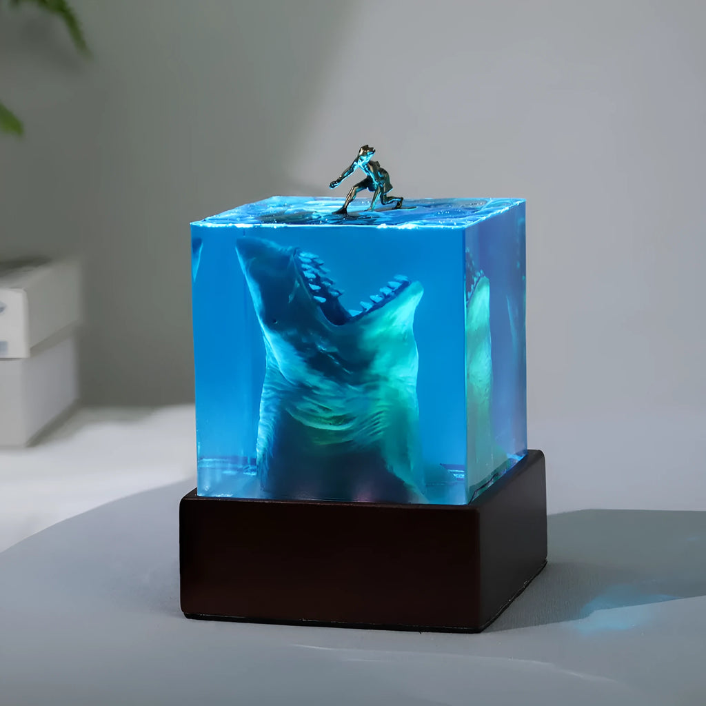 Epoxy resin shark surfer night light ornament with crystal glue details on blue background