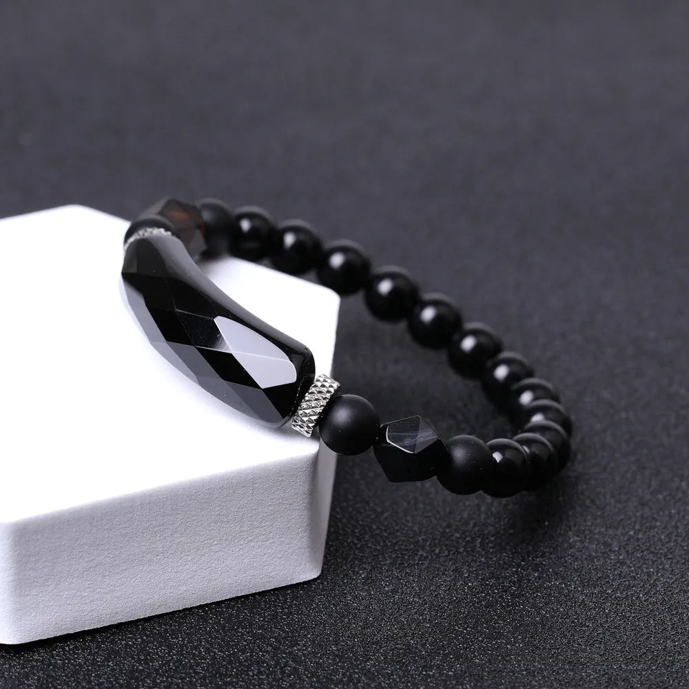 Handmade diamond-shaped cut agate bracelet in a geometric, fan-shaped design on a wrist.