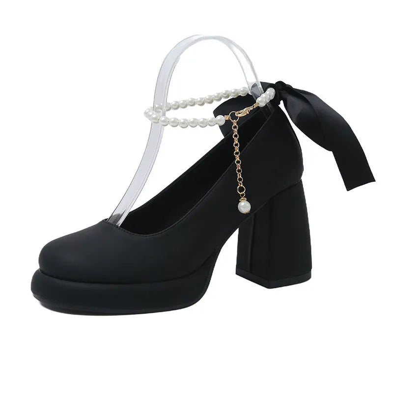 Beige women's Mary Jane shoes with a chunky heel, round toe, and ankle strap with a pearl and buckle.