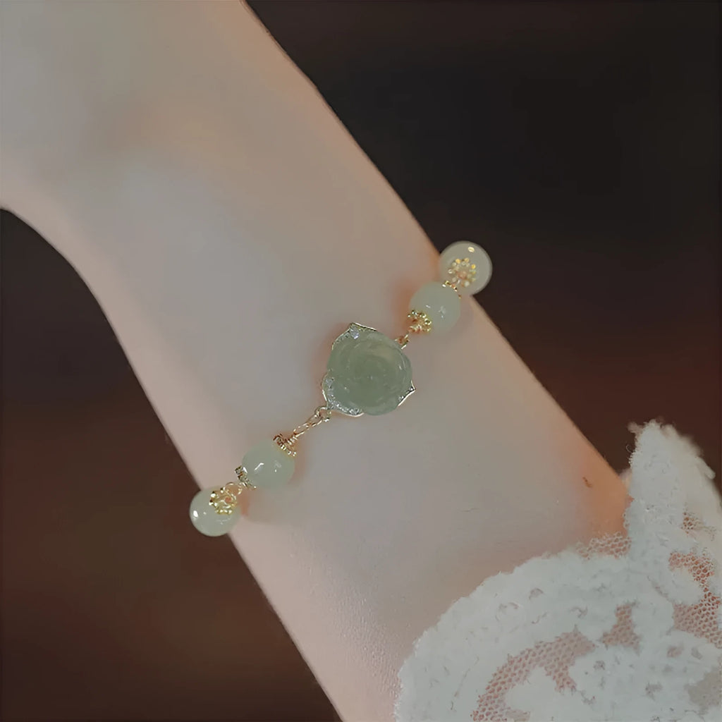 Women's Hetian Jade bracelet with carved rose design and 14K gold gilding on floral-shaped band