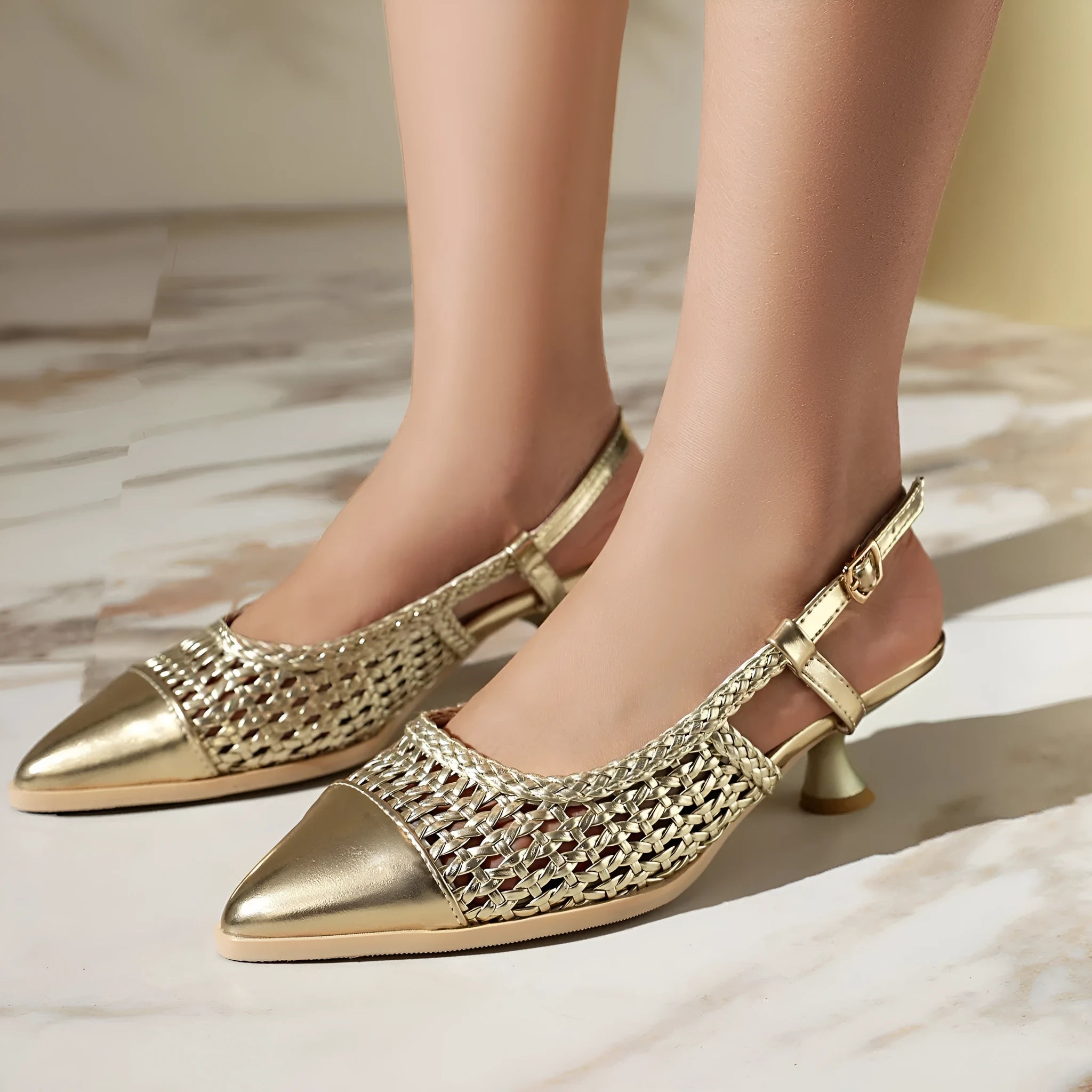 Gold women's sandals with a cat heel, buckle strap, and rubber sole.