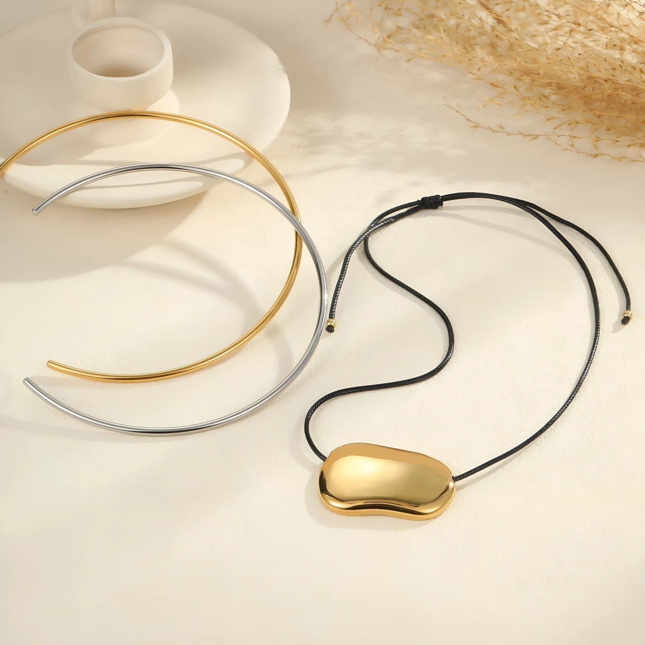 Close-up of a minimalist geometric pendant on an adjustable stainless steel necklace chain.