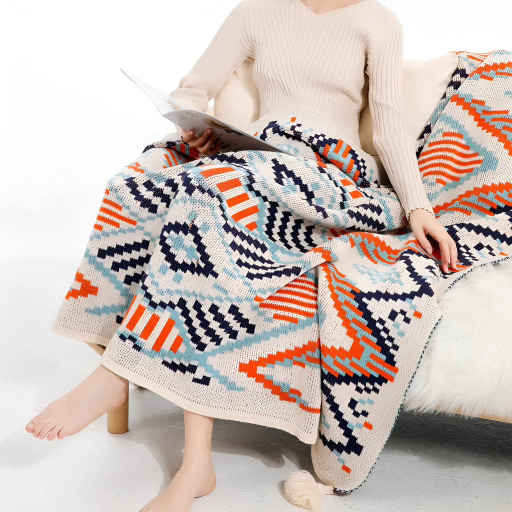 Acrylic sofa blanket with tassels in geometric pattern colour option on a sofa