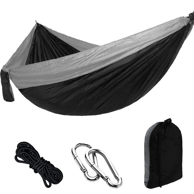 Double camping hammock with ropes and buckles shown in outdoor setting