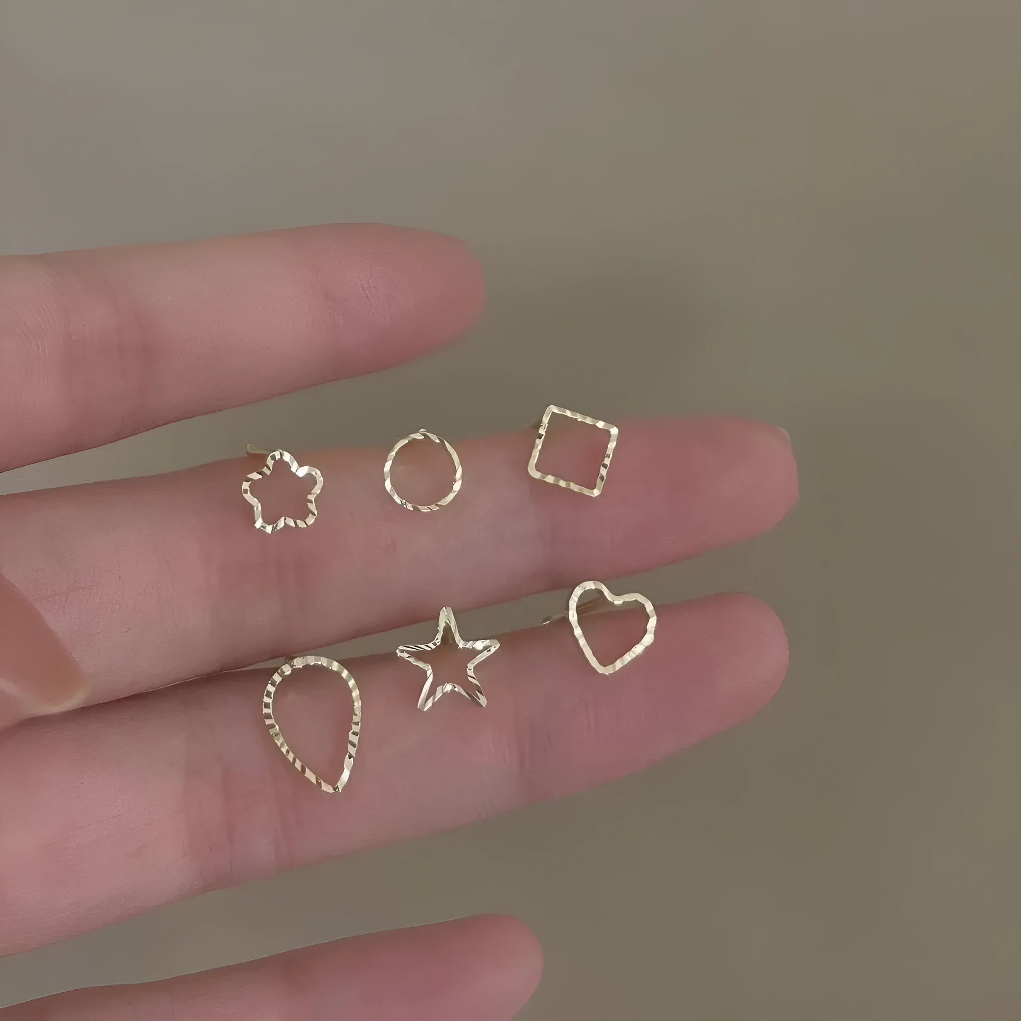 Small spiral geometric ear studs in gold hollow thread design with mixed material build and electroplated finish