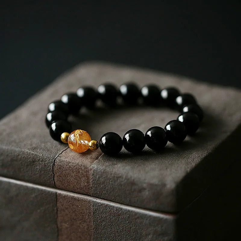 Geometric obsidian and white crystal beaded bracelet with golden dragon charm on adjustable band
