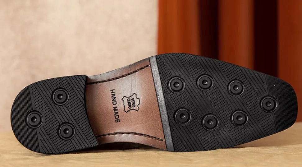 Men's black and brown British-style leather slip-on loafers showing polished leather upper and rubber sole