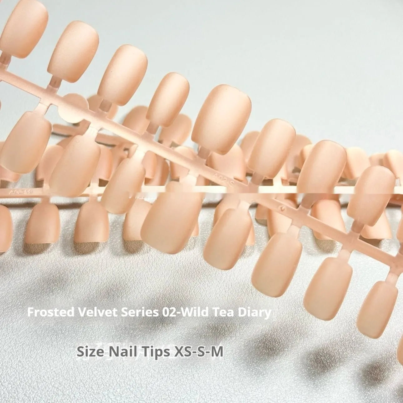 Set of velvet frosted Cat's Eye false nails in short ladder XS, S, and M sizes on a display stand.