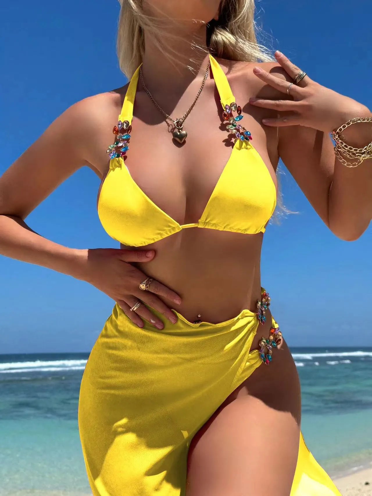 Rose red mesh long skirt three-piece bikini swimsuit set laid flat.
