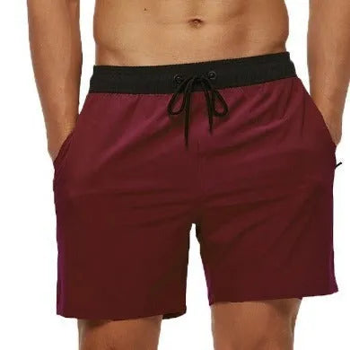 Men's blue fitness shorts with stitched waist headband, drawstring, zipper pocket, and padding for running