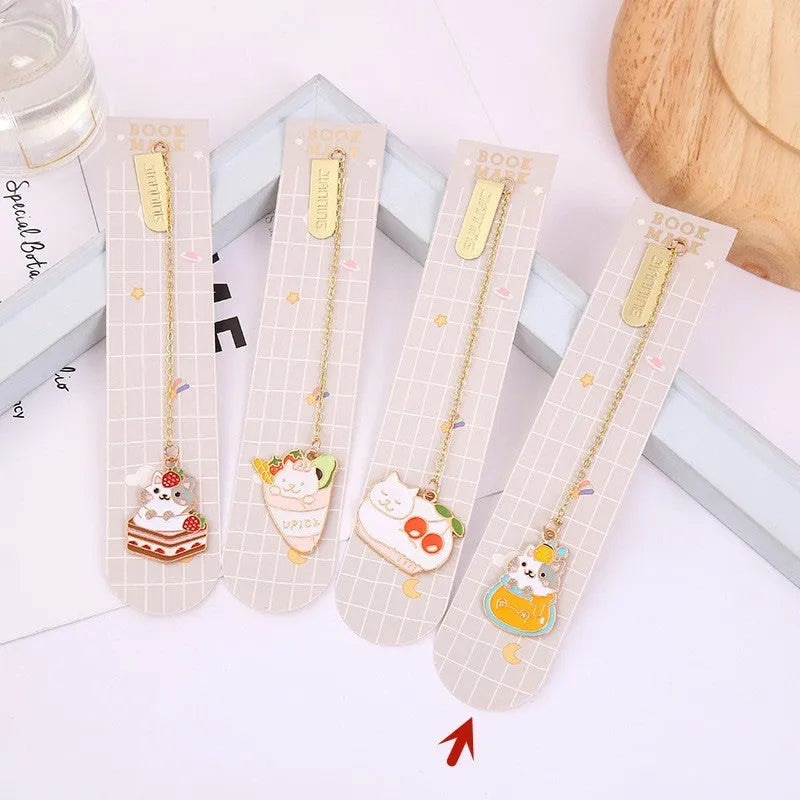 Metal cartoon cat bookmark with food-themed designs including strawberry cake and fruit roll styles