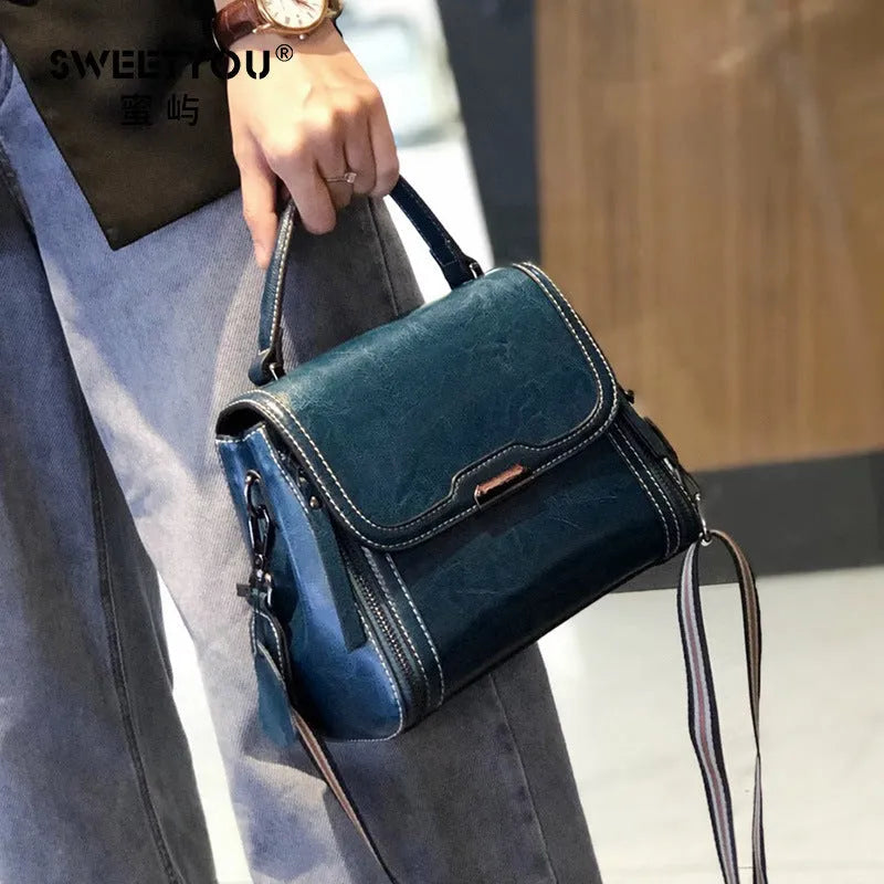 Women's brown genuine oil wax leather messenger bag showing front view with double straps and visible sewing details.