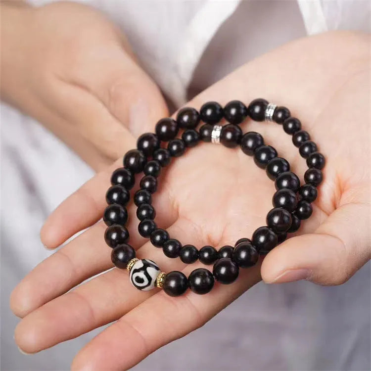 Solid ebony wood bracelet with 8mm Tibetan beads showing two-circle pattern