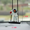 Resin cartoon astronaut car pendant available in red flag, telescope, and radish holding styles for dashboard decoration.