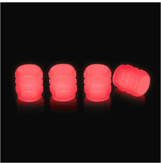 Pack of green and blue luminous rubber tyre valve caps on a car tyre valve.