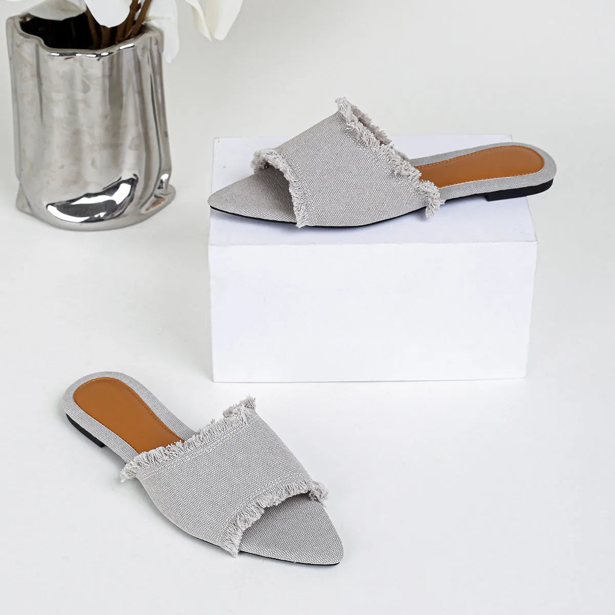 Women's denim flat slippers with a tassel, leather lining, and a PVC sole in various colours.