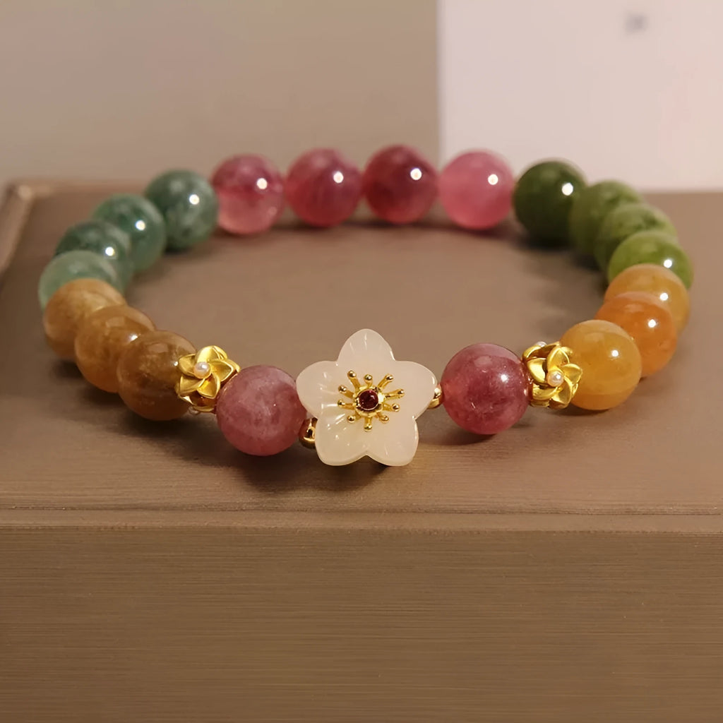 Natural colour tourmaline bracelet with floral beads and geometric design on wrist