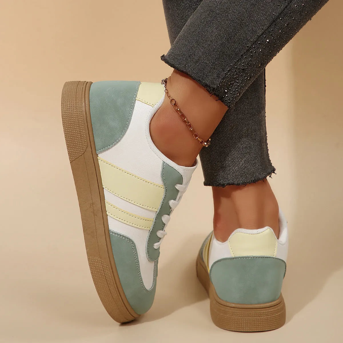 Green women's retro trainers with a cross strap design, round toe, and white rubber sole.