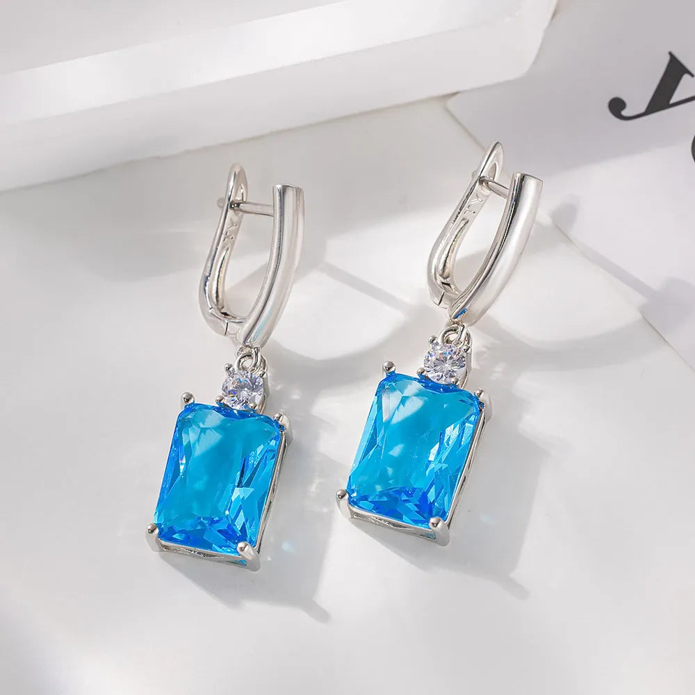 A pair of square geometric earrings with a quadrilateral design in a gold or silver electroplated finish.