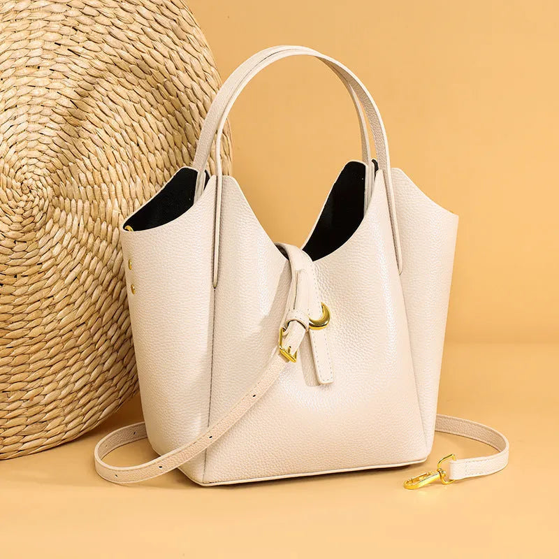 Genuine leather women's retro bucket handbag in beige with top handles and visible stitching.