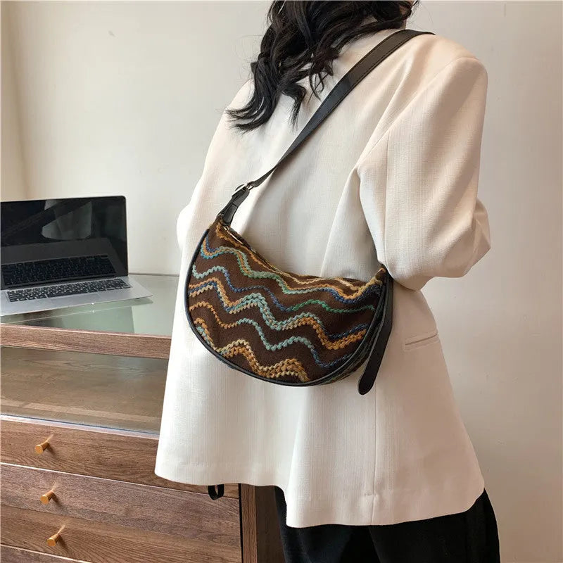 Women's straw woven crossbody bag showing woven texture and internal phone and document compartments