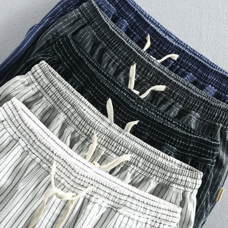 Man wearing black and white striped cotton casual shorts with a loose straight leg and elasticated waist.