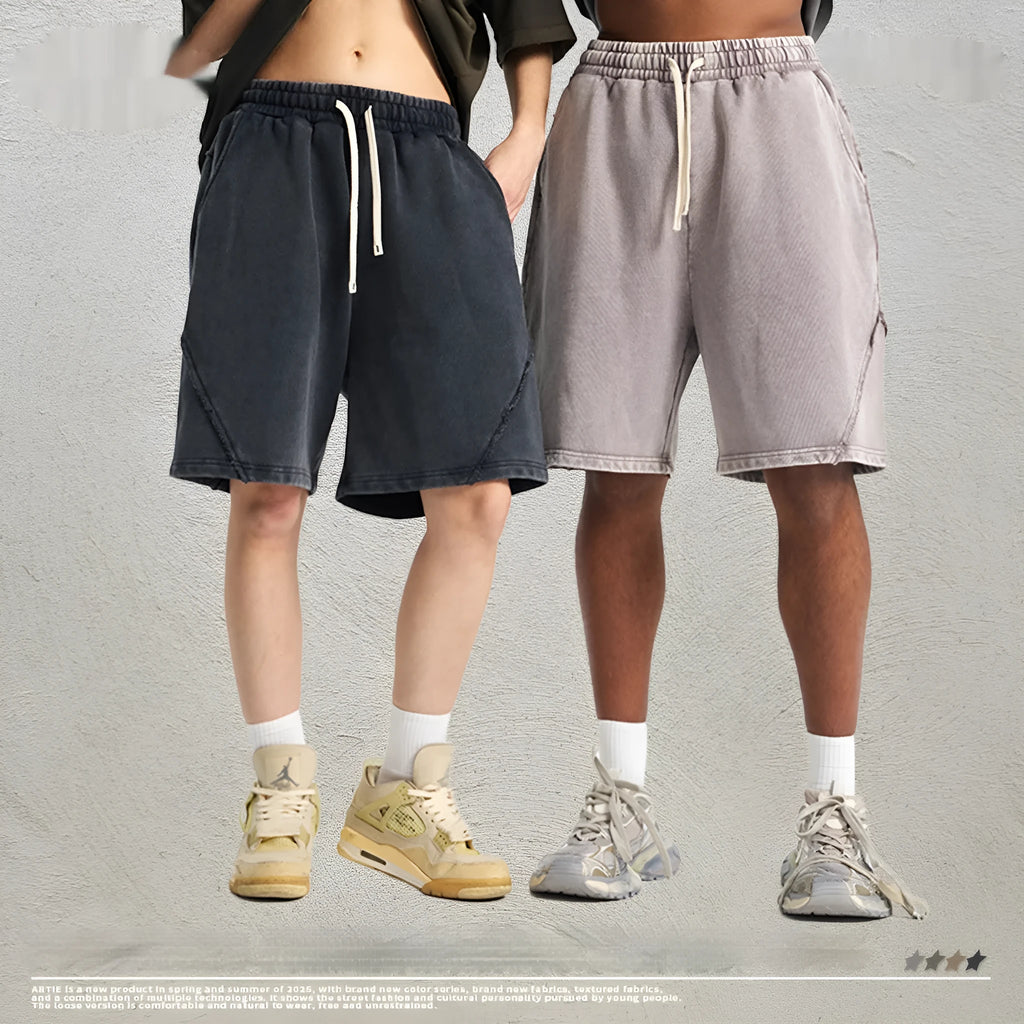 Man wearing loose fit batik washed cotton terry shorts with patch craft detailing in a street fashion style.