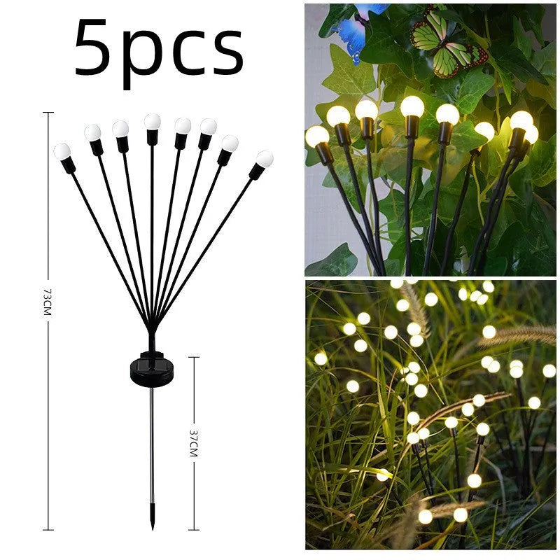 Solar-powered LED firefly lawn light with ground stake inserted in grass