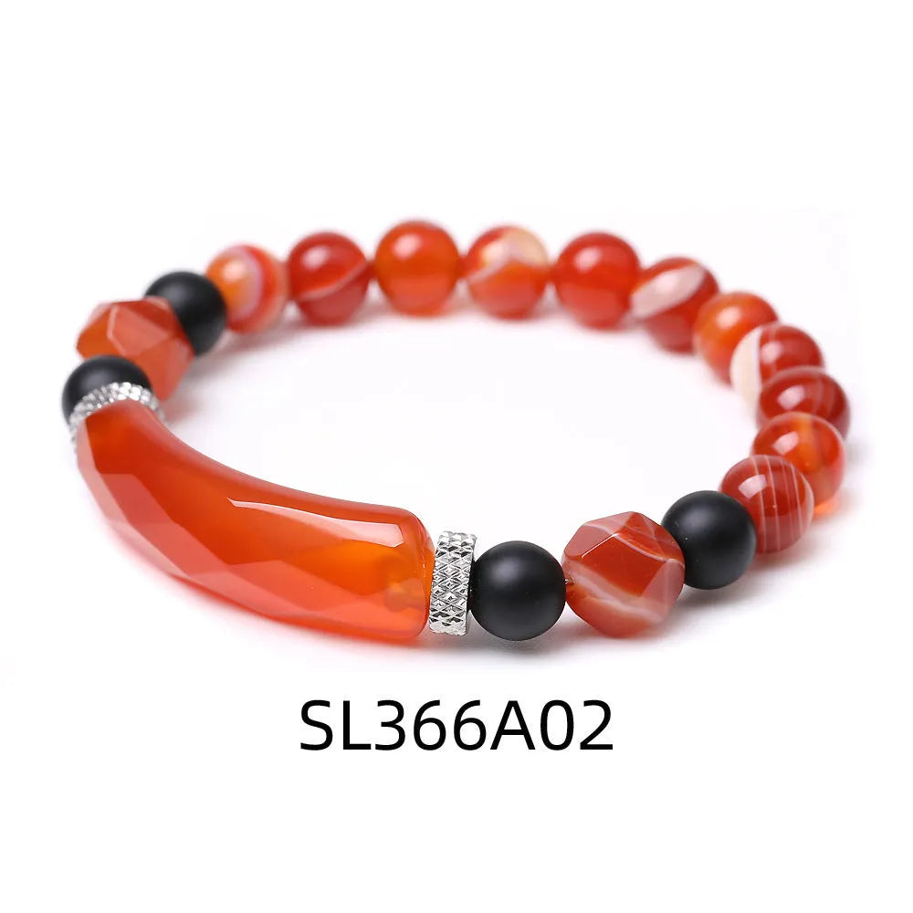 Handmade diamond-shaped cut agate bracelet in a geometric, fan-shaped design on a wrist.