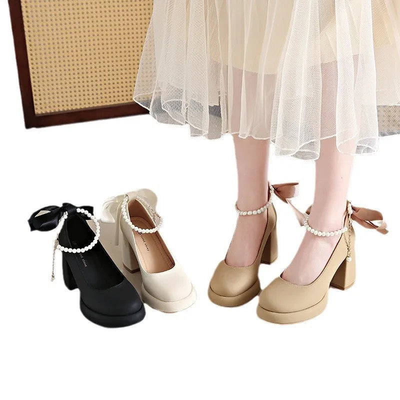 Beige women's Mary Jane shoes with a chunky heel, round toe, and ankle strap with a pearl and buckle.