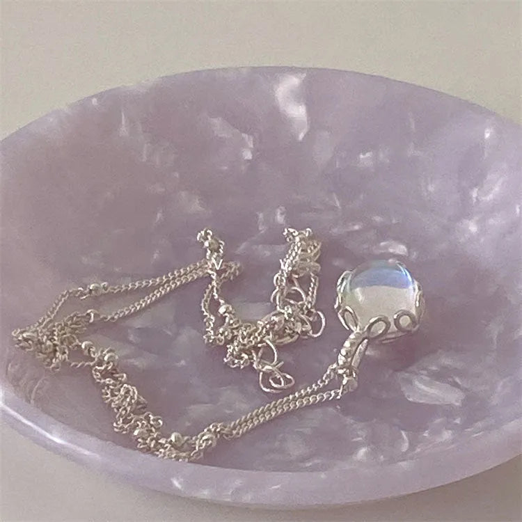 Polished sterling silver necklace for women with round geometric stone pendant on curb chain.
