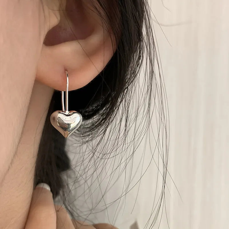 Silver colour heart-shaped earrings with glossy finish and three-dimensional Korean style design