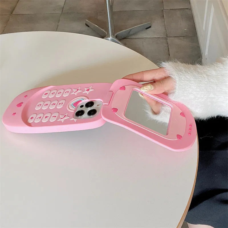 Pink silicone flip phone case open to show built-in mirror and iPhone compatibility.