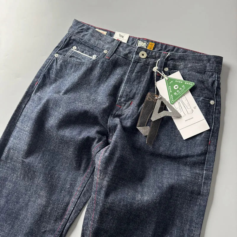 Men's straight leg denim trousers in a primary blue wash, showing front view on a hanger.
