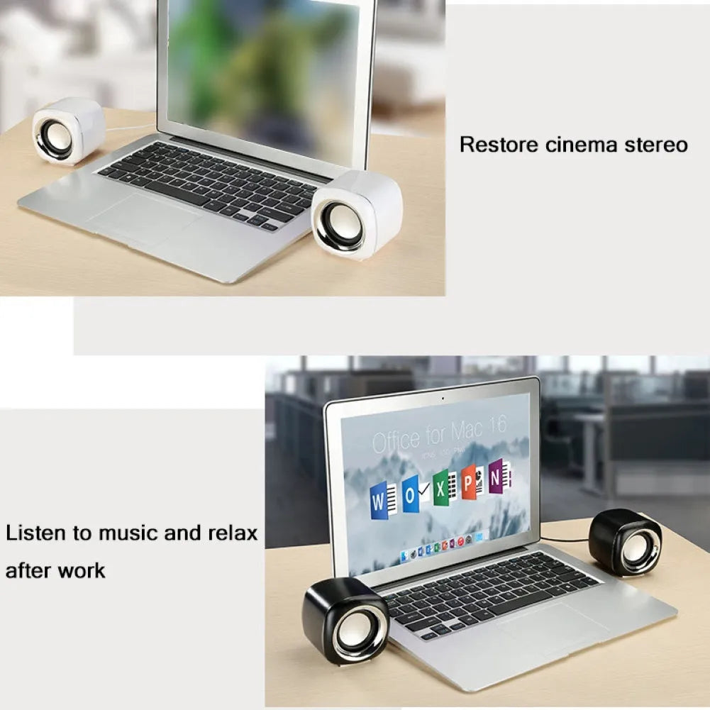 Pair of compact black wired desktop computer speakers with top volume scroll wheel next to a laptop.