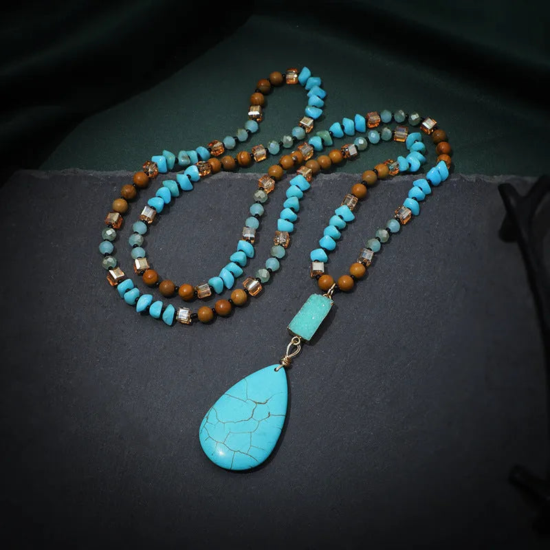 Turquoise blue water drop pendant necklace with geometric shapes on a long ball bead chain.