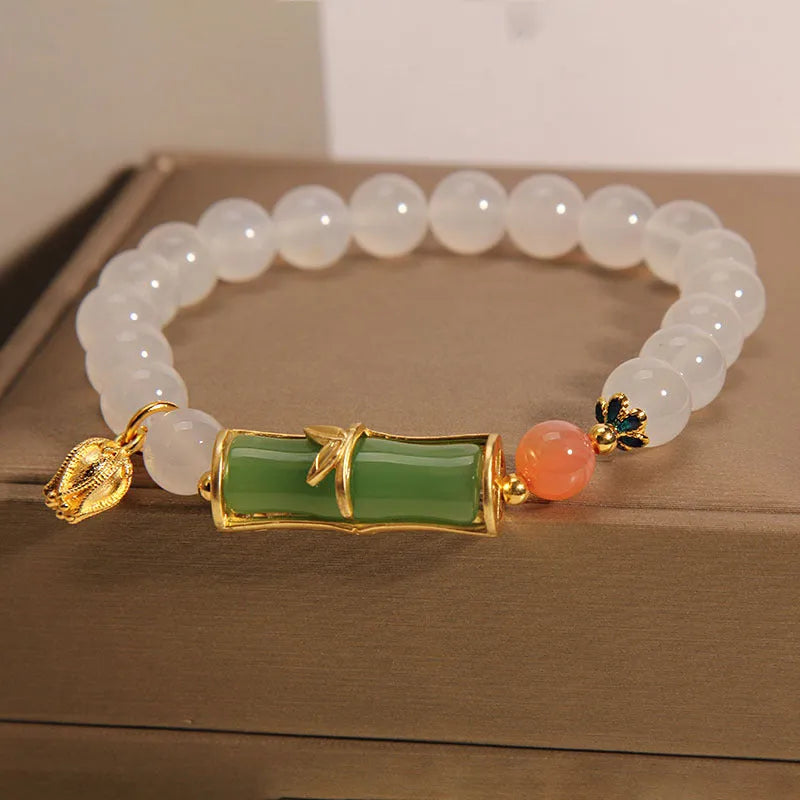 Women's white agate jade bracelet with bamboo joint beads on a wrist.